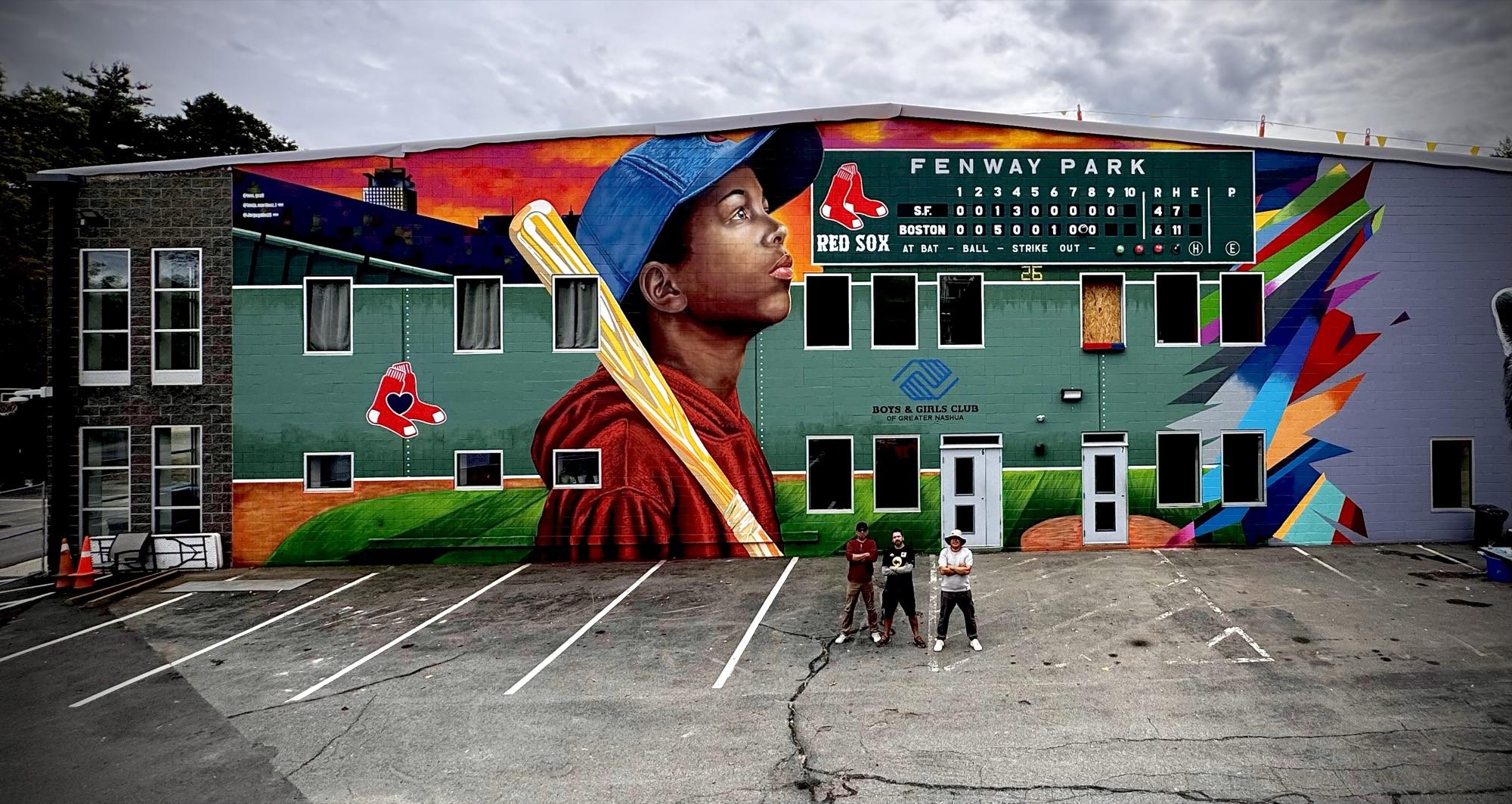 Building-sized mural of a young baseball player with a Fenway Park scoreboard